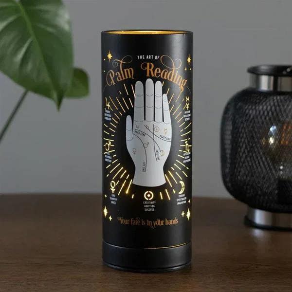 Black electric aroma lamp cylinder with palm reading artwork on tabletop
