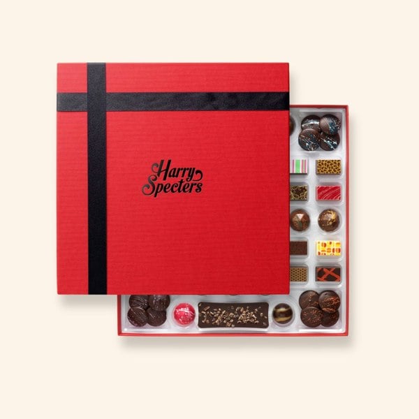 A Harry Specters chocolate box with with chocolate bars, buttons, and coffee beans partially covered by a lid 