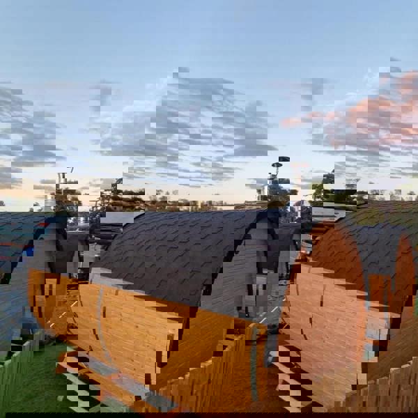 Wooden barrel saunas with a scenic sky view.