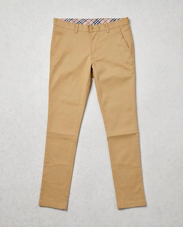 Beige pants with a brand label on a light gray background