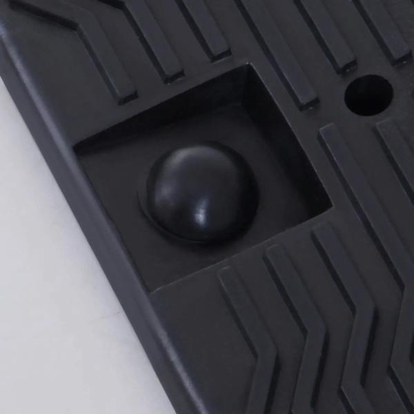 Close-up of black plastic car ramp traction insert in a recessed grid section