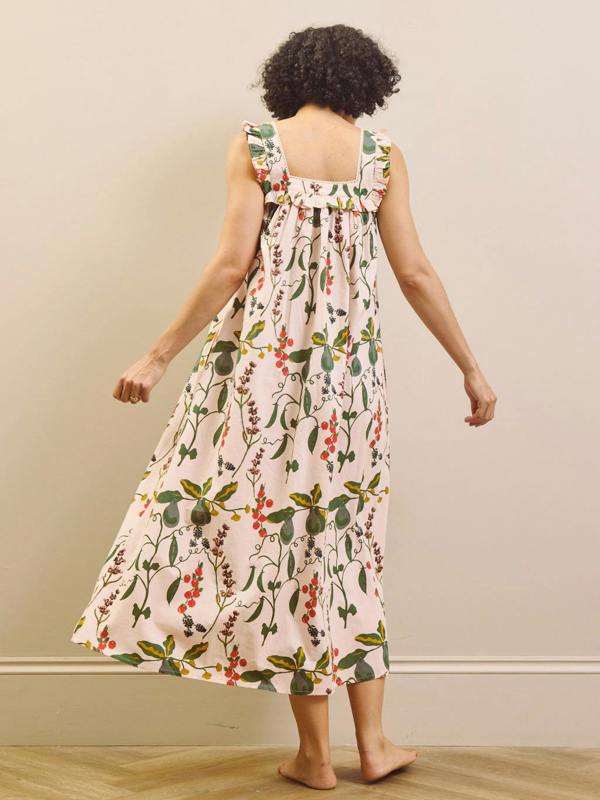 Woman wearing a floral & Pear night dress against a plain background