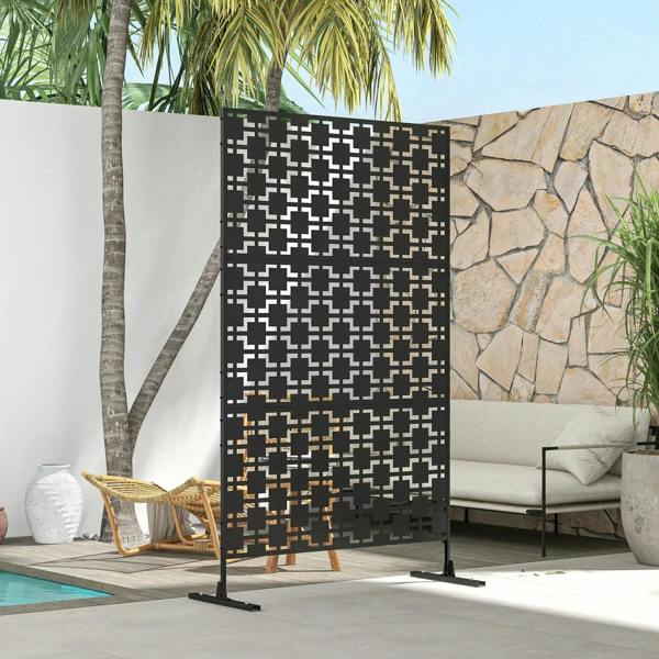Black metal privacy screen divider with geometric cutout design on patio beside seating