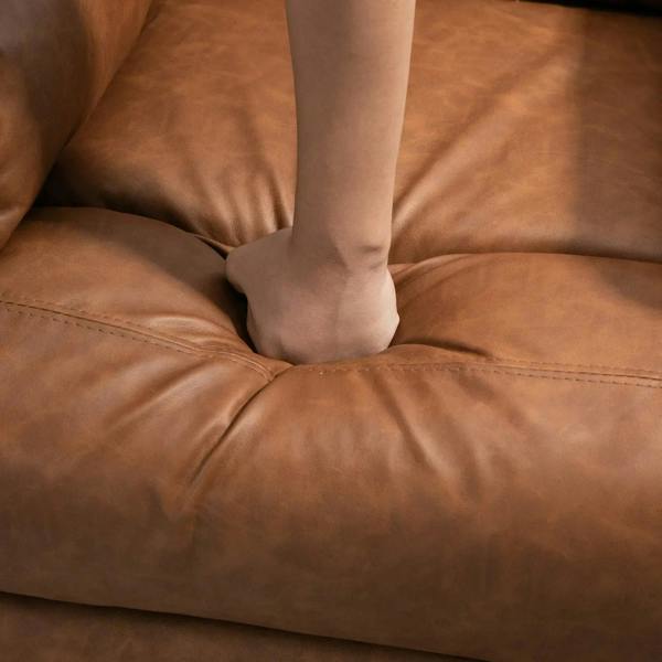 Brown faux leather recliner seat upholstery with stitched seams and visible footrest area
