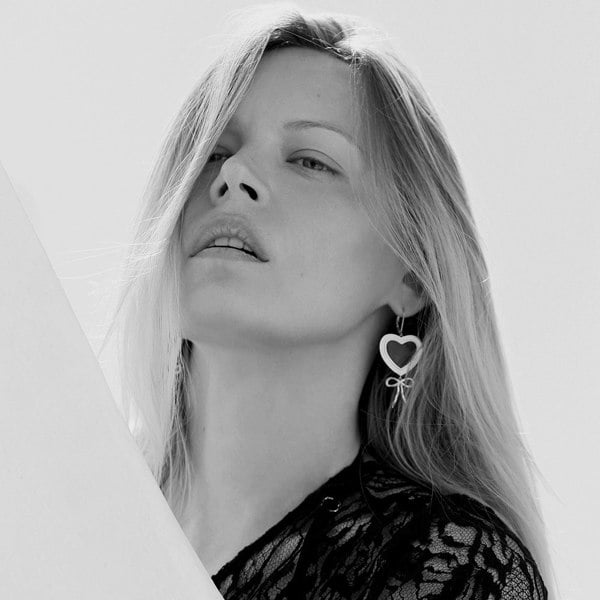 A face of a model with heart earrings, black and white image.