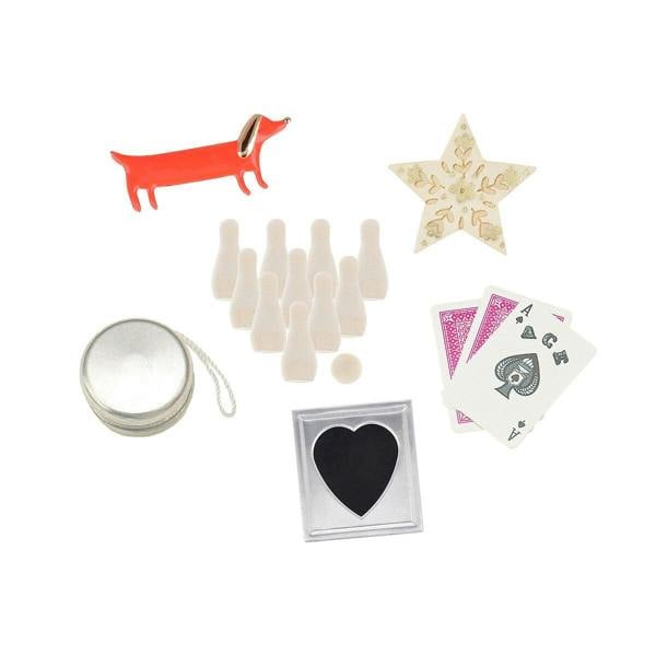 Six high-quality keepsake cracker gifts including an enamel sausage dog pin, mini wooden skittles, a metal yo-yo, and playing cards against a white background.