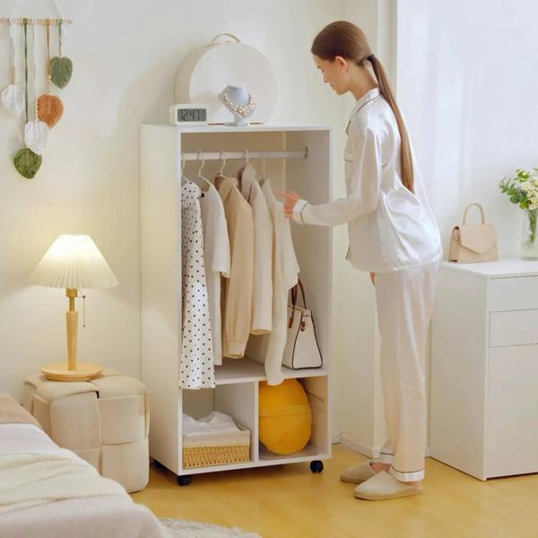 White mobile wardrobe with hanging clothes and open shelves on caster wheels