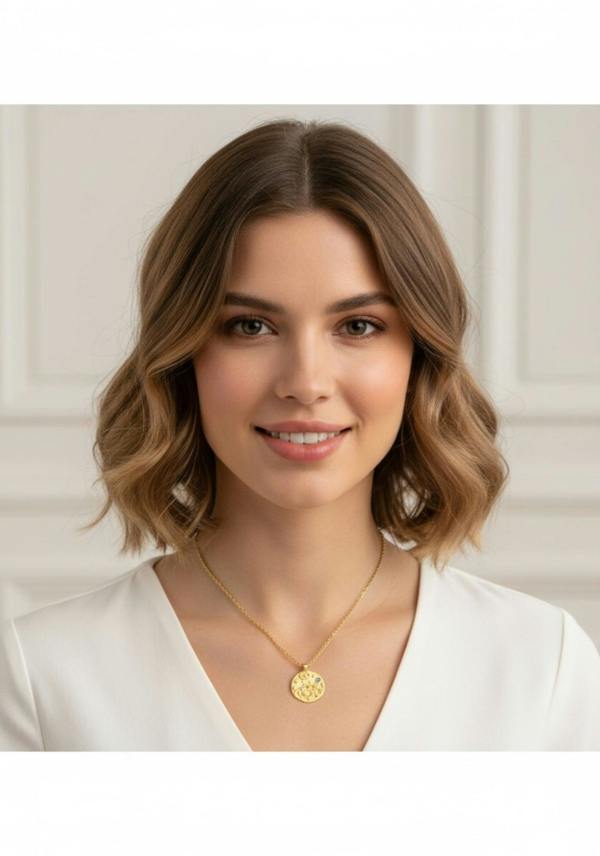 Woman wearing a gold necklace with a pendant against a white background