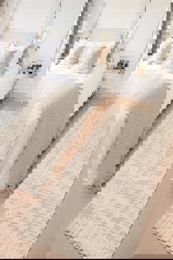 Ava Pave Wave Illusion Rug in cream, featuring abstract design on a soft carpet in a modern bedroom setting.