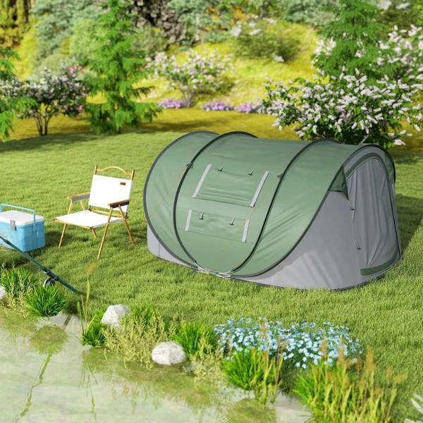 Dark green and gray pop-up camping tent staked on grass beside a small pond with rocks