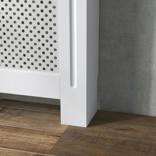 White radiator cover cabinet corner with leg and side panel beside perforated grille.