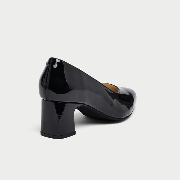 Black patent leather shoe on a light gray background