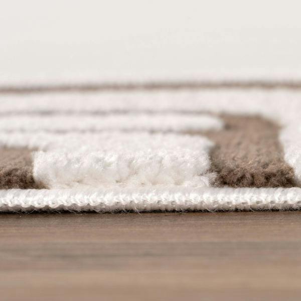 Close-up of a textured rug with brown, white, and beige colors on a wooden floor.