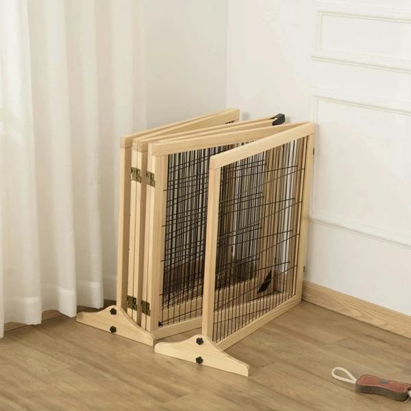 Folded freestanding pet gate with natural wood frame and black wire mesh, on support feet.