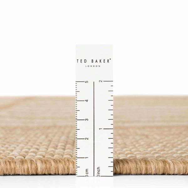 Beige woven mat with a ruler and 'Ted Baker' branding on a white background