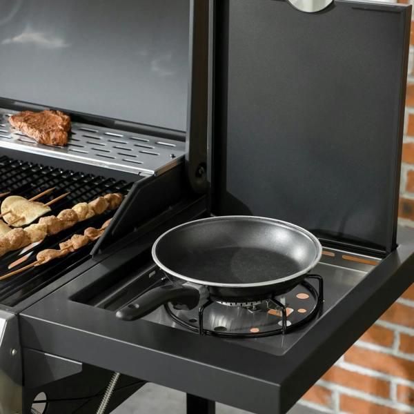 Black gas grill with side burner and skillet on the side shelf