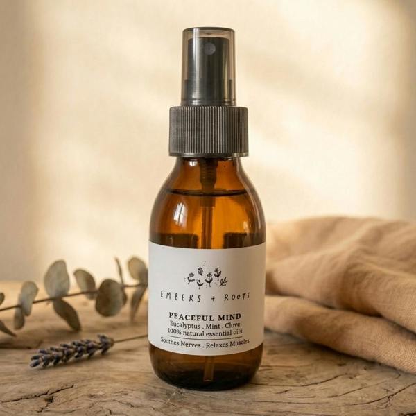 Peaceful Mind luxury aromatherapy room spray mist in a 100ml amber glass bottle by Abode Home & Gifts, styled in warm sunlight with lavender and eucalyptus