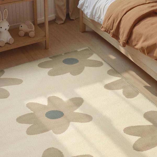 Floral patterned rug on a wooden floor with a bed and shelf in the background.