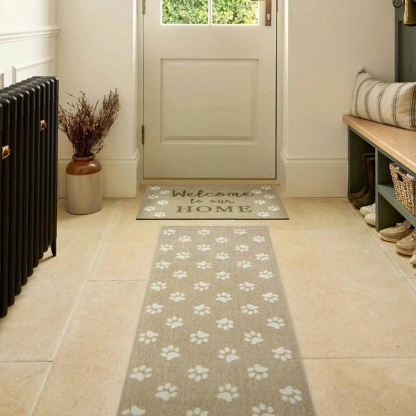 Home entrance with a 'Welcome to our HOME' mat and a paw print patterned rug.