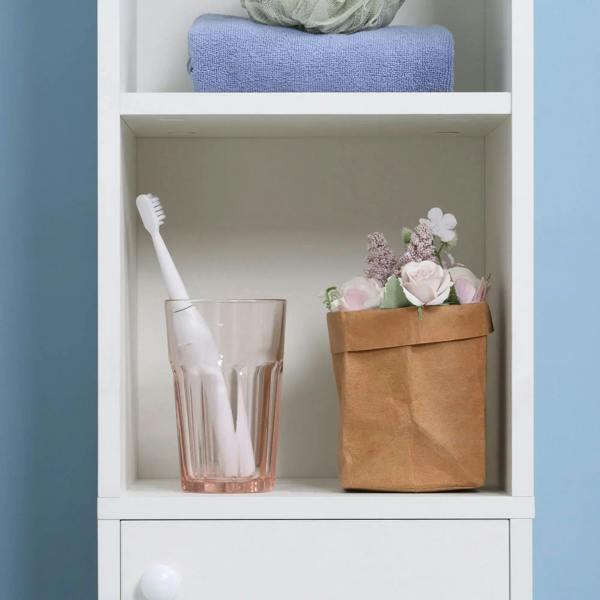 White cabinet open shelf with bathroom items, including toothbrush holder