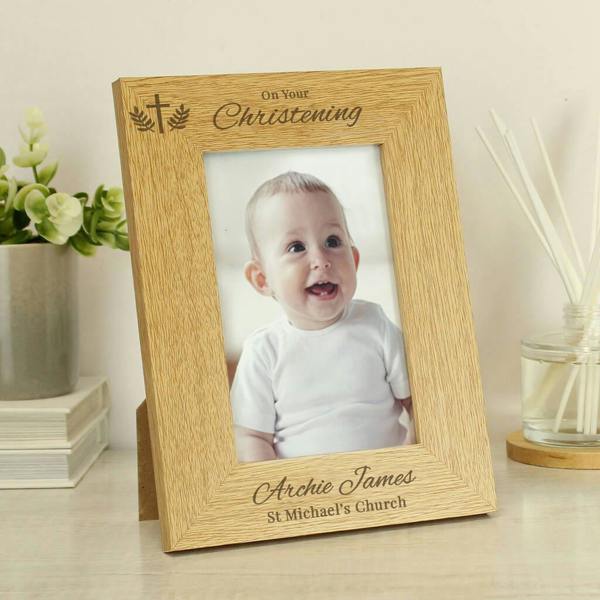 An oak veneer Personalised Christening Photo Frame engraved with Archie James St Michael's Church holding a portrait photo of a smiling baby.