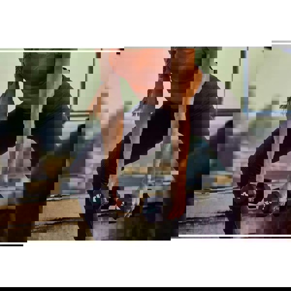 Person exercising with 4kg dumbbells on a rooftop with cityscape background