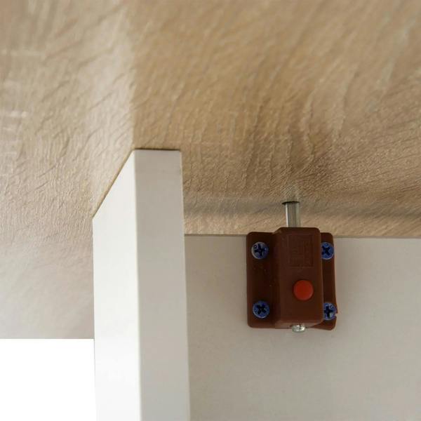Close-up of drop-leaf table hinge bracket on white frame under oak tabletop.