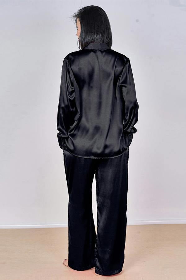 Person wearing a black satin outfit against a white background