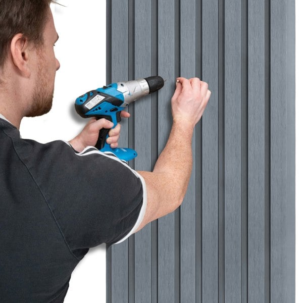 WPC slatted wall cladding panels in grey, showcasing a person installing them with a drill against a white wall background