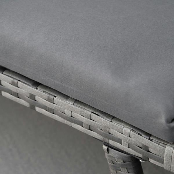 Grey sofa cushion edge and grey rattan weave detail on armrest