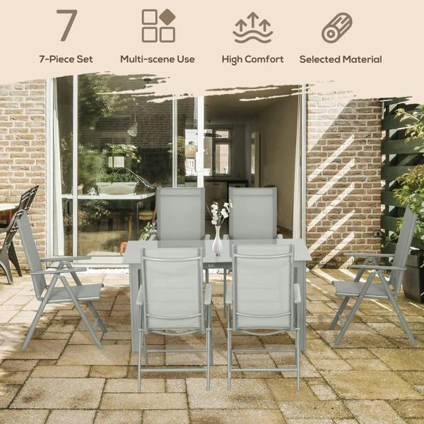 Grey folding reclining outdoor dining chairs with armrests around a rectangular glass table.