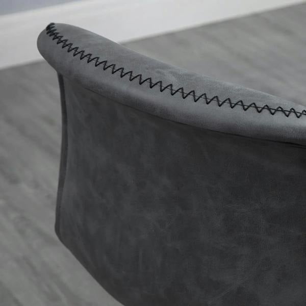 Close-up of dark grey bar stool armrest edge with zigzag stitched trim