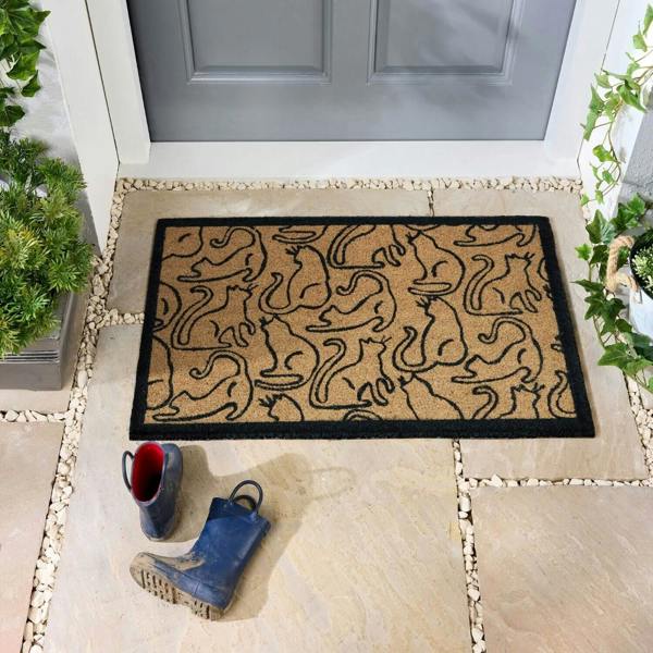 Doormat with cat pattern on a stone patio outside a door