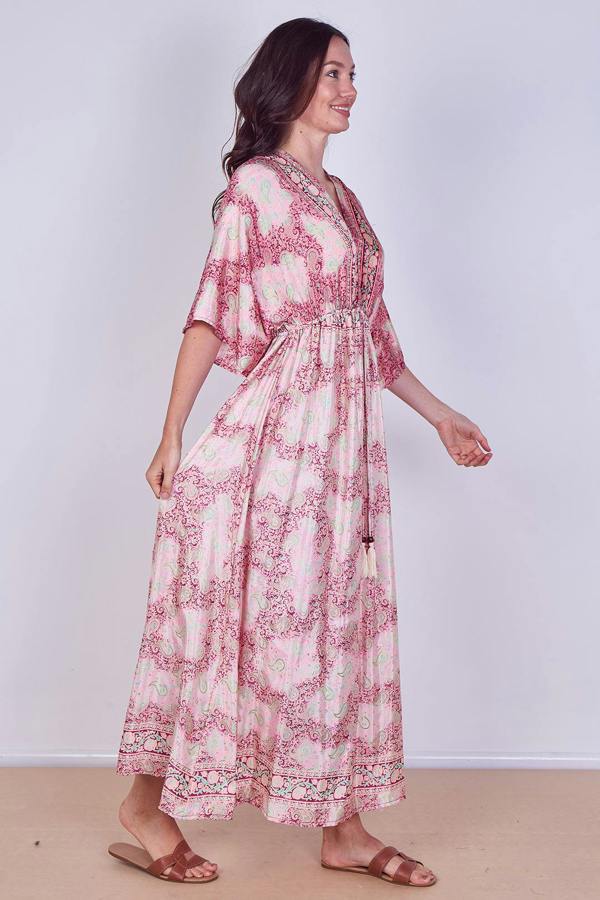 Woman wearing a pink floral dress against a white background