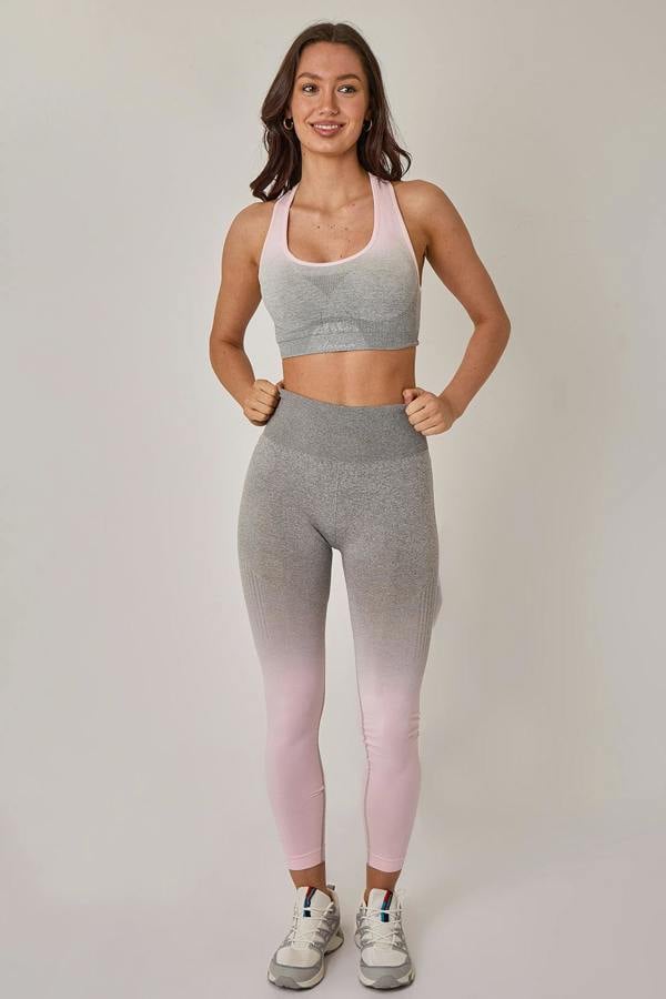 Woman wearing a gray and pink gradient athletic outfit on a plain background