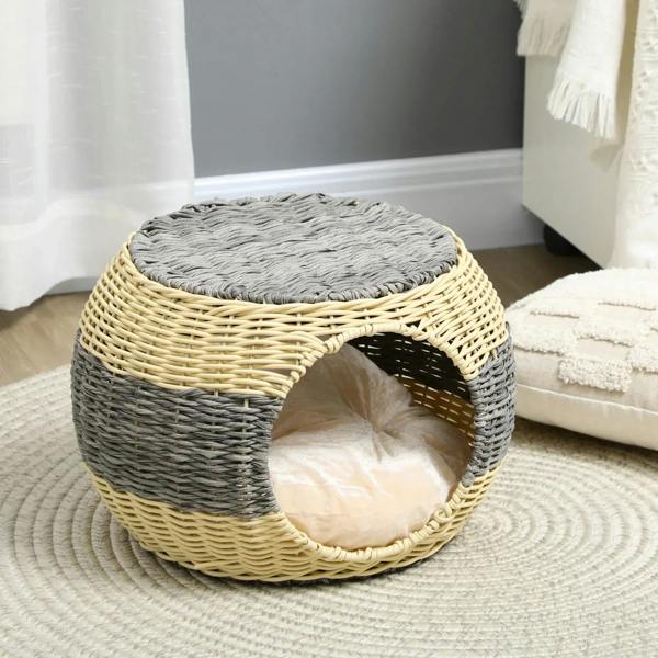 Round wicker cat house with gray top cushion and beige inner cushion.