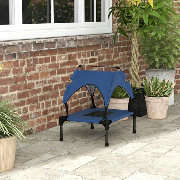 Dark blue raised pet bed with canopy and breathable mesh, placed on outdoor patio