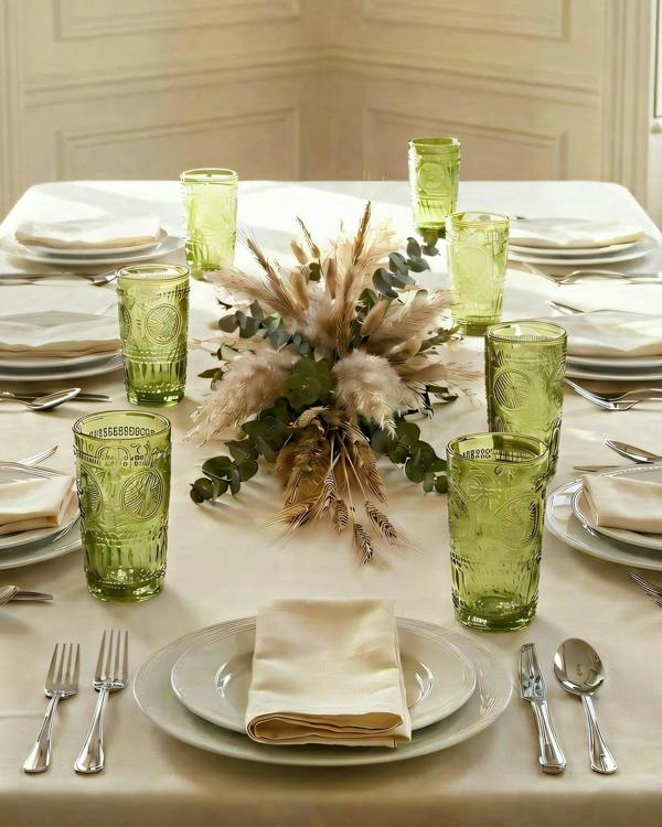 Two green textured glasses on a white surface with a white background