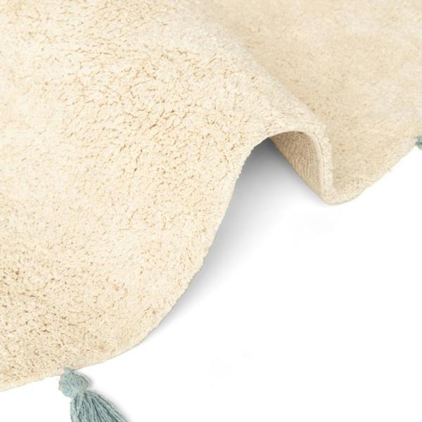 Close-up of a beige textured rug with a tassel on a white background