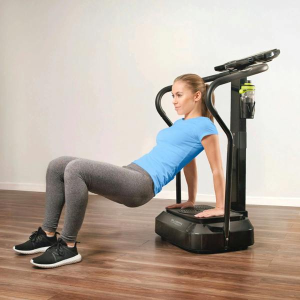 Woman in blue shirt performing tricep dips on a fitness machine with a water bottle holder