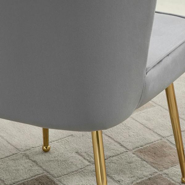 Grey upholstered chair arm and corner detail with smooth velvet-feel fabric and gold legs