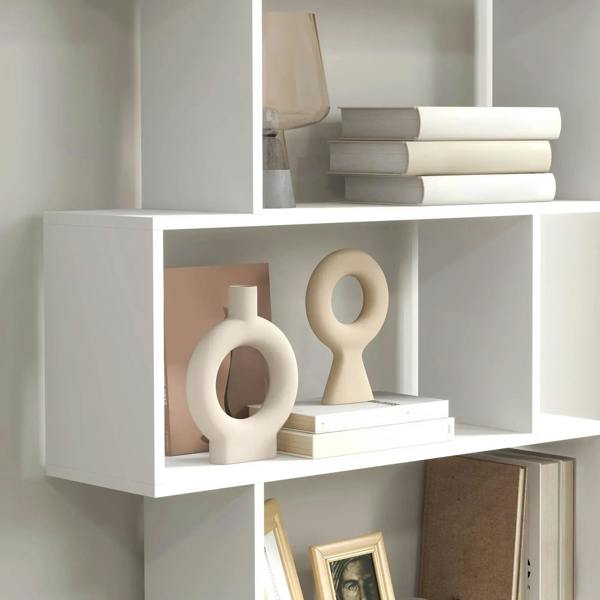 White bookshelf lower shelves with decorative vases and stacked books on display