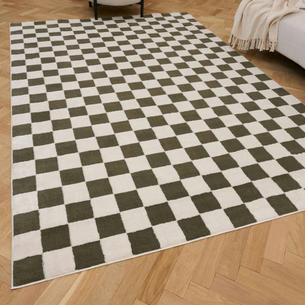 Checkered rug with green and white squares on a wooden floor