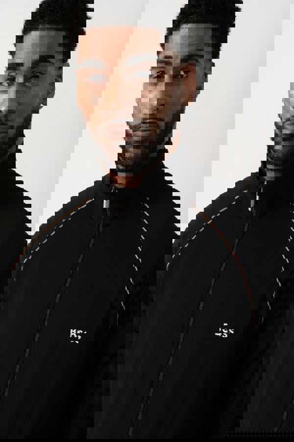 Close up shot of a Model wearing a BOSS Orange Mix&Match Mens Logo-Embroidered Full Zip Loungewear Jacket in black Stretch-Cotton Jersey