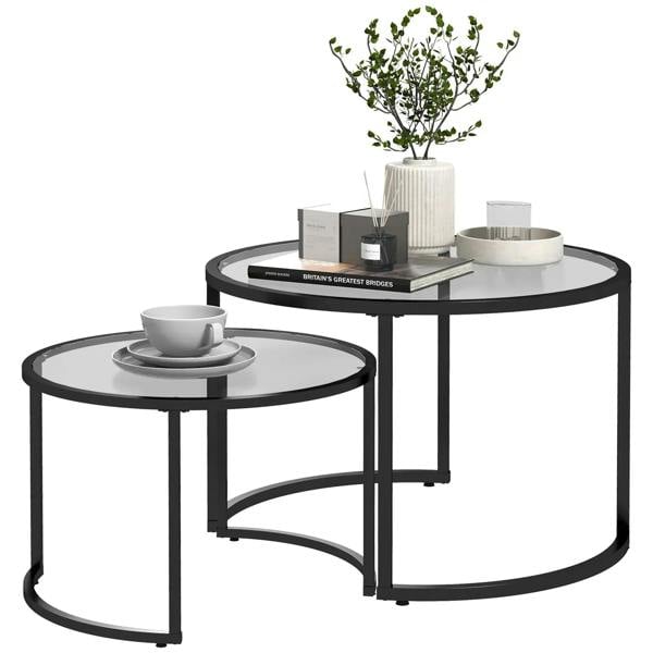 Black two-piece nest coffee tables with round glass tops and arched metal legs.