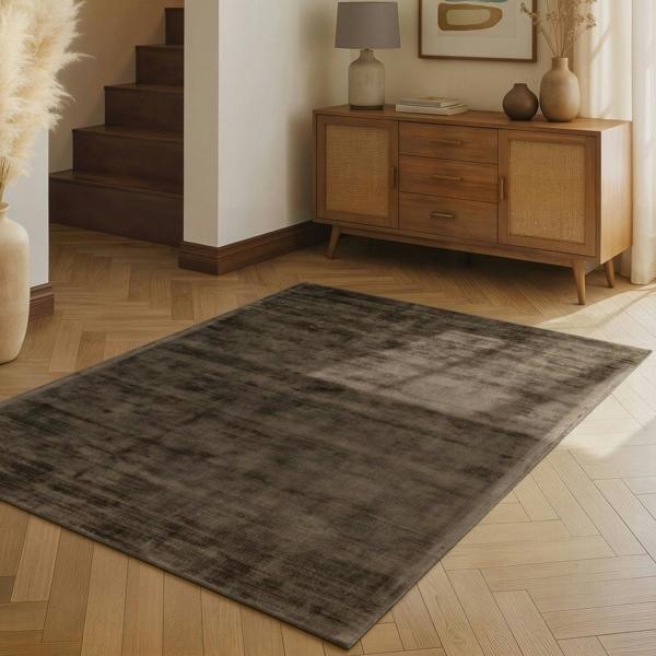 Gray rug on a wooden floor with a wooden sideboard in the background