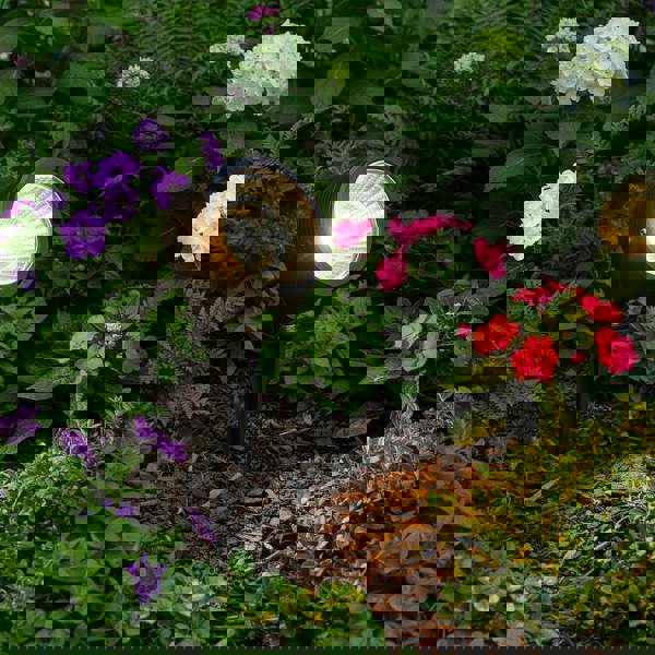 black pathway stake light installed in a garden border 