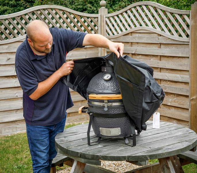 Dellonda DG182 Kamado Accessories Action shot - putting - cover - on