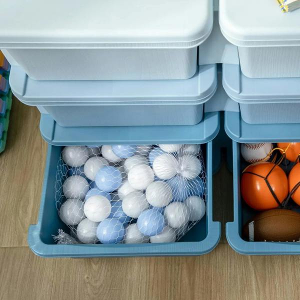 Blue storage unit drawer open with balls and small toys, molded front handle