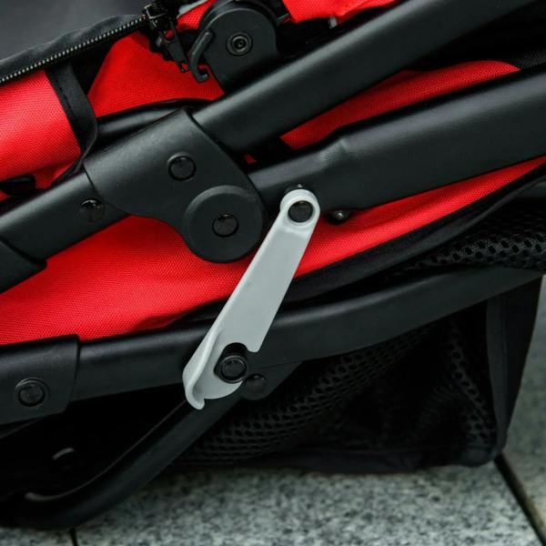 Red and black pet stroller folding handle and locking mechanism detail